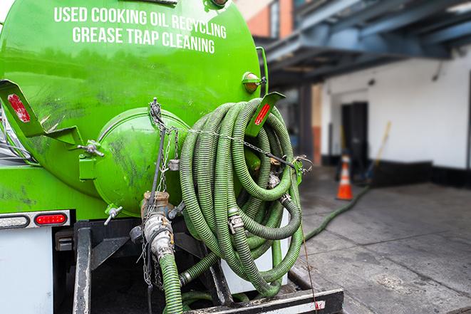 a technician pumping a grease trap in a commercial building in Woodcrest CA